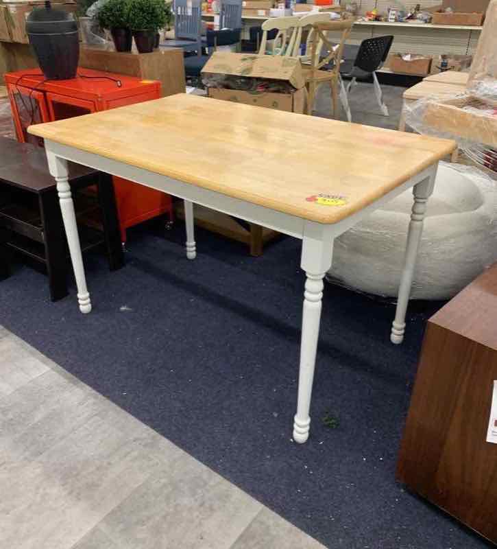 Farmhouse dining table with upholstered side chairs on the showroom floor