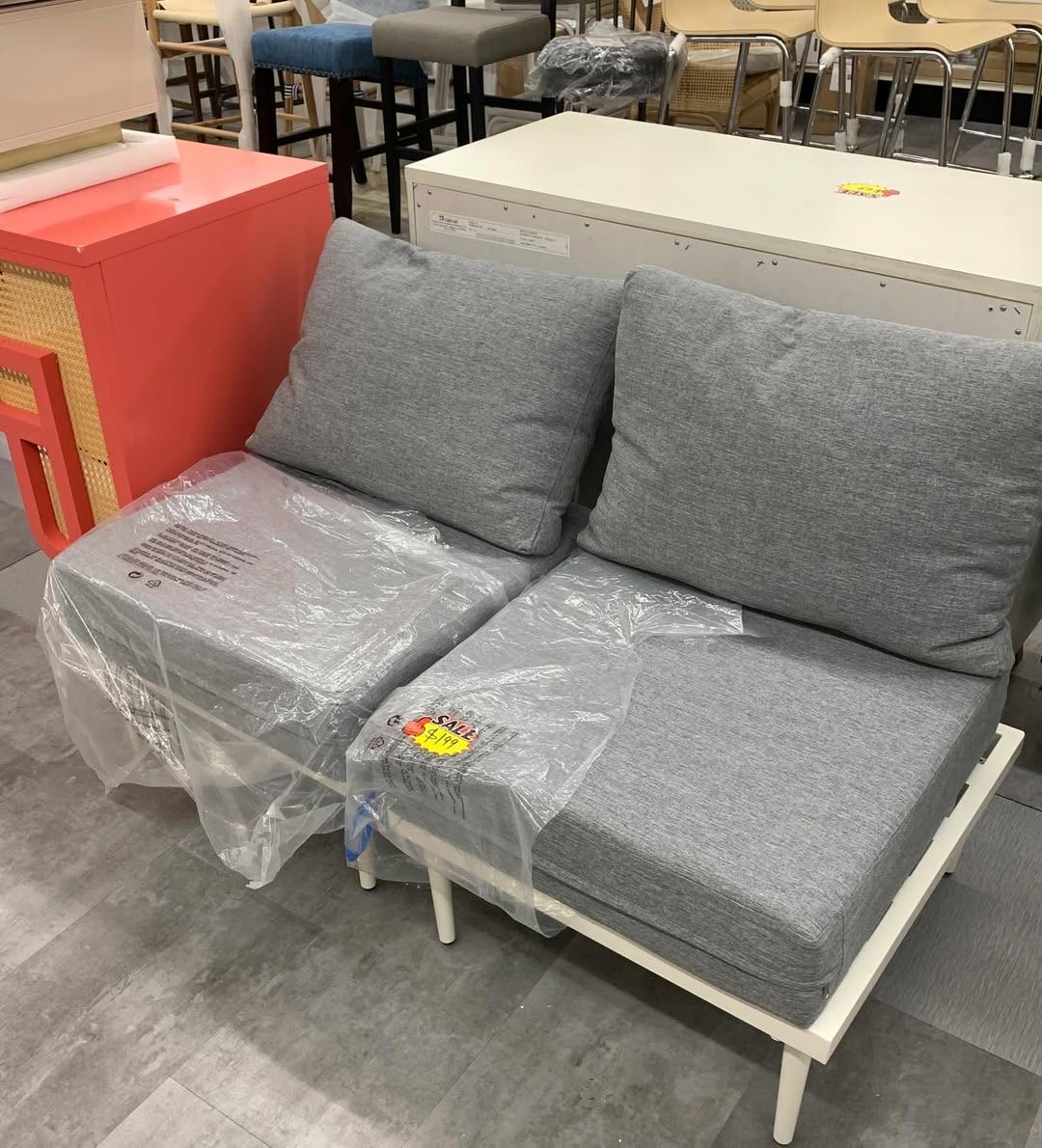 Grey upholstered loveseat on the 123 Home Outlet floor