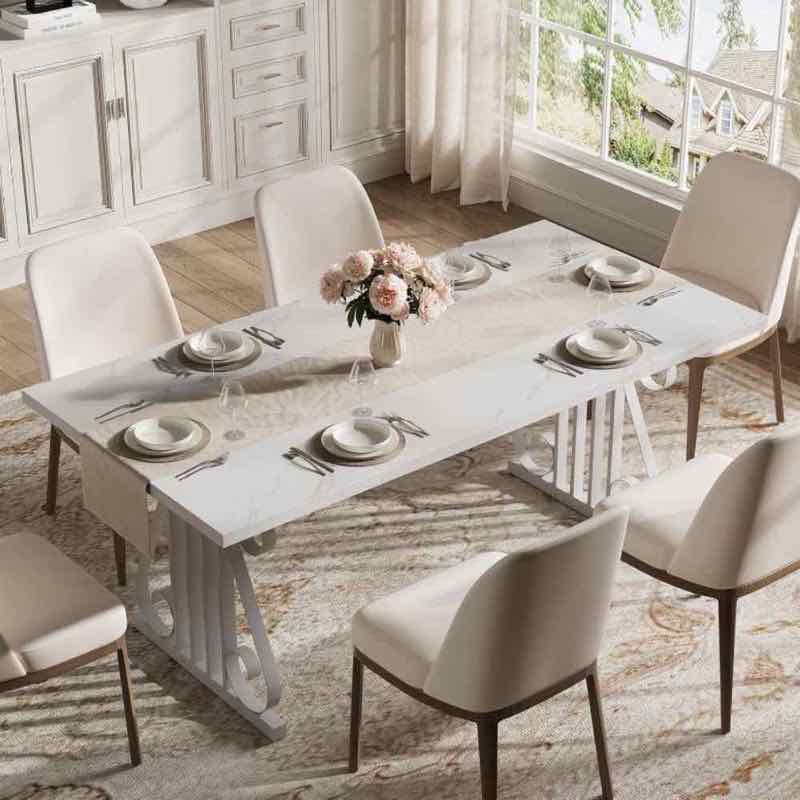 White faux-marble top dining table with six cream upholstered chairs in a styled dining room
