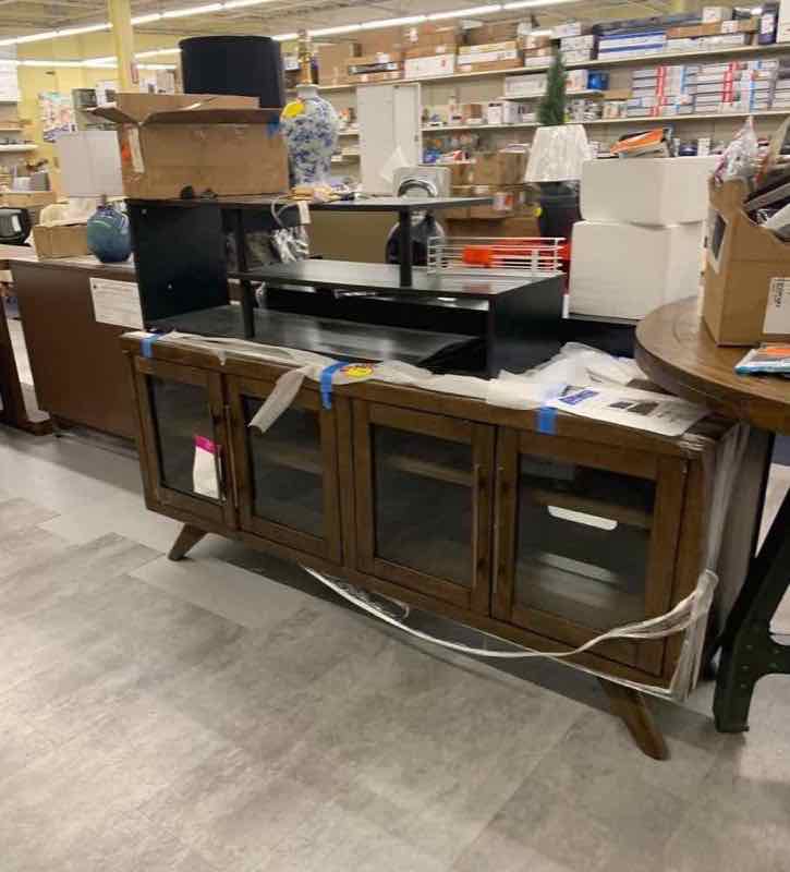 Walnut horizontal-slatted media console TV stand with glass doors on the store floor